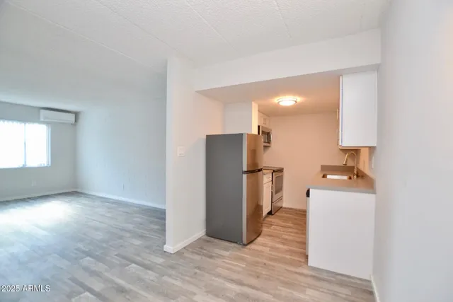 a view of a kitchen with a refrigerator a microwave and a sink