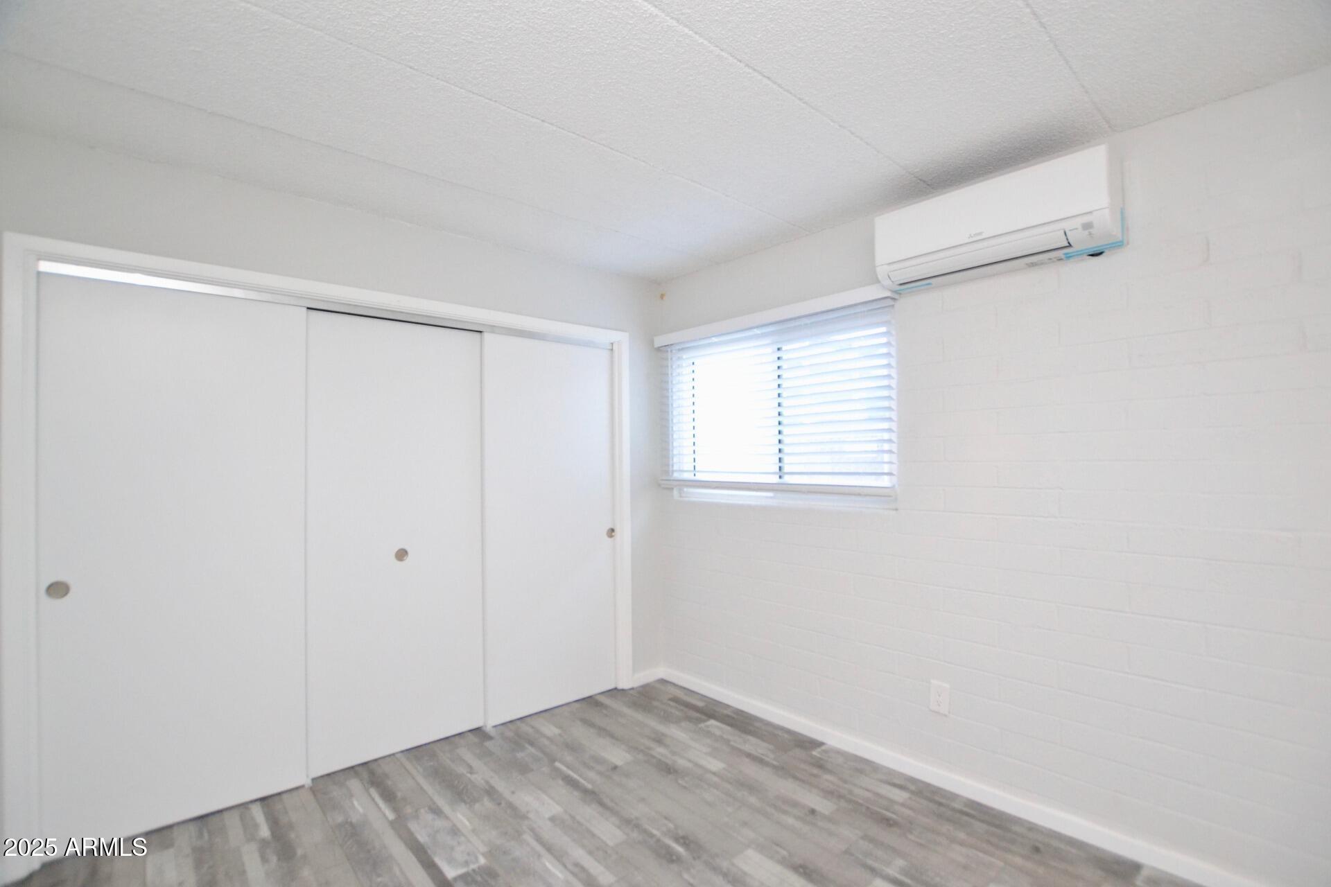 44 East Roanoke Avenue, Unit 4 Phoenix, AZ 85012 - Photo 8 of 19 a view of an empty room with wooden floor and a window