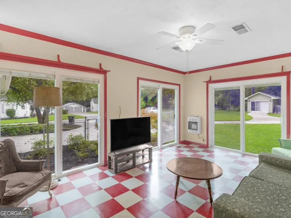 a living room with garden a flat screen tv and a floor to ceiling window