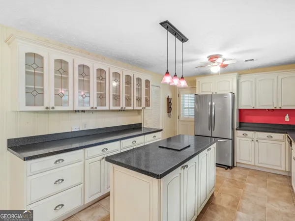 a kitchen with granite countertop a sink cabinets and stainless steel appliances