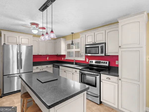 a kitchen with stainless steel appliances a sink stove and refrigerator