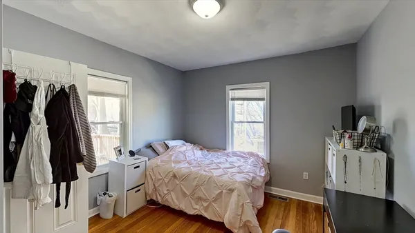 a bedroom with a bed and a flat tv screen on the dresser