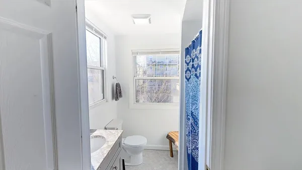 a bathroom with a granite countertop toilet a sink and a mirror