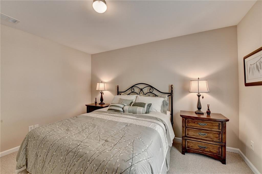 6415 Hampton Rock Lane Cumming, GA 30041 - Photo 11 of 26 a bedroom with a bed and a lamp