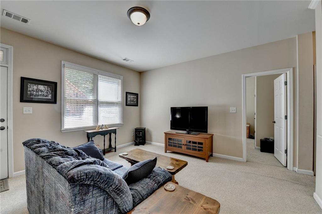 6415 Hampton Rock Lane Cumming, GA 30041 - Photo 13 of 26 a living room with furniture and a flat screen tv