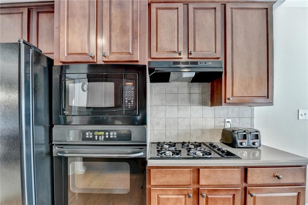 6415 Hampton Rock Lane Cumming, GA 30041 - Photo 7 of 26 a kitchen with granite countertop a stove and cabinets