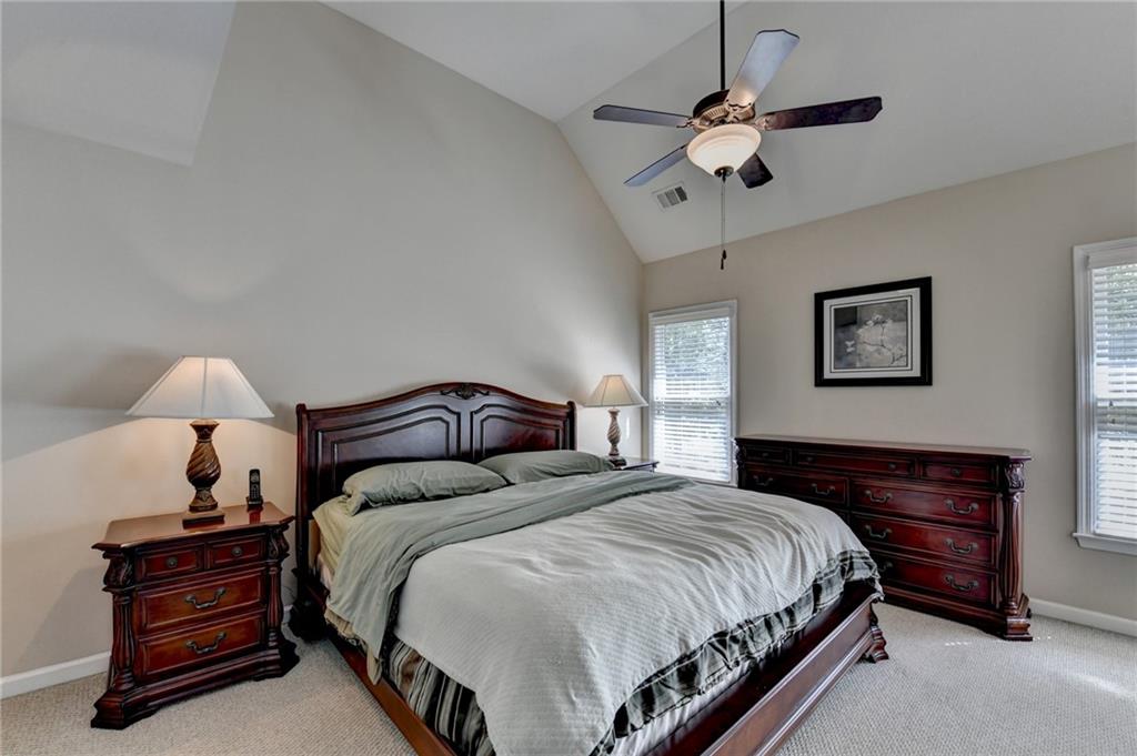 6415 Hampton Rock Lane Cumming, GA 30041 - Photo 8 of 26 a spacious bedroom with a bed and a chandelier