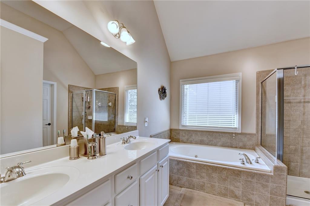 6415 Hampton Rock Lane Cumming, GA 30041 - Photo 9 of 26 a bathroom with a tub a double vanity sink and a mirror