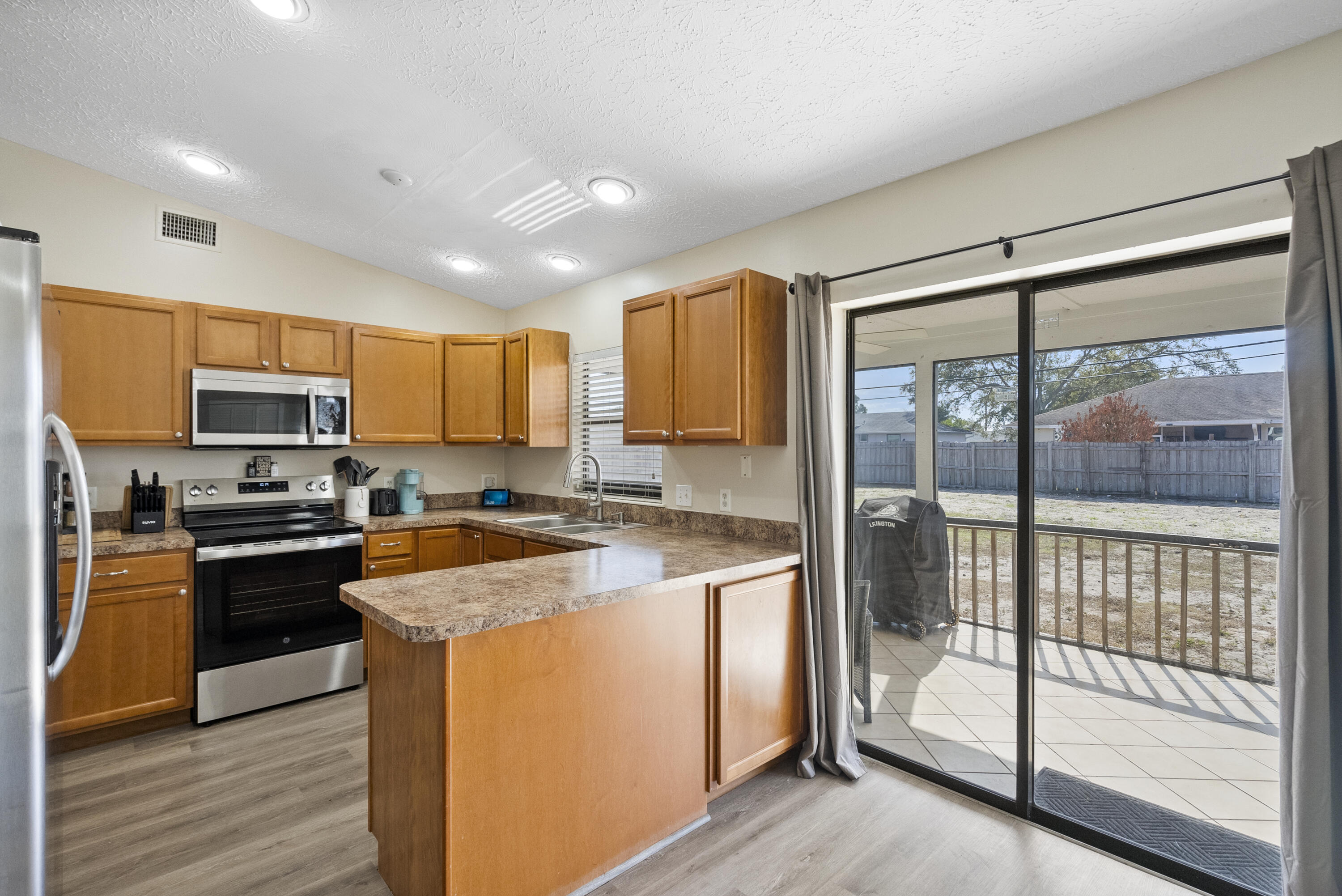822 Southwest Harvard Road Port St. Lucie, FL 34953 - Photo 12 of 43 a kitchen with stainless steel appliances granite countertop a stove top oven