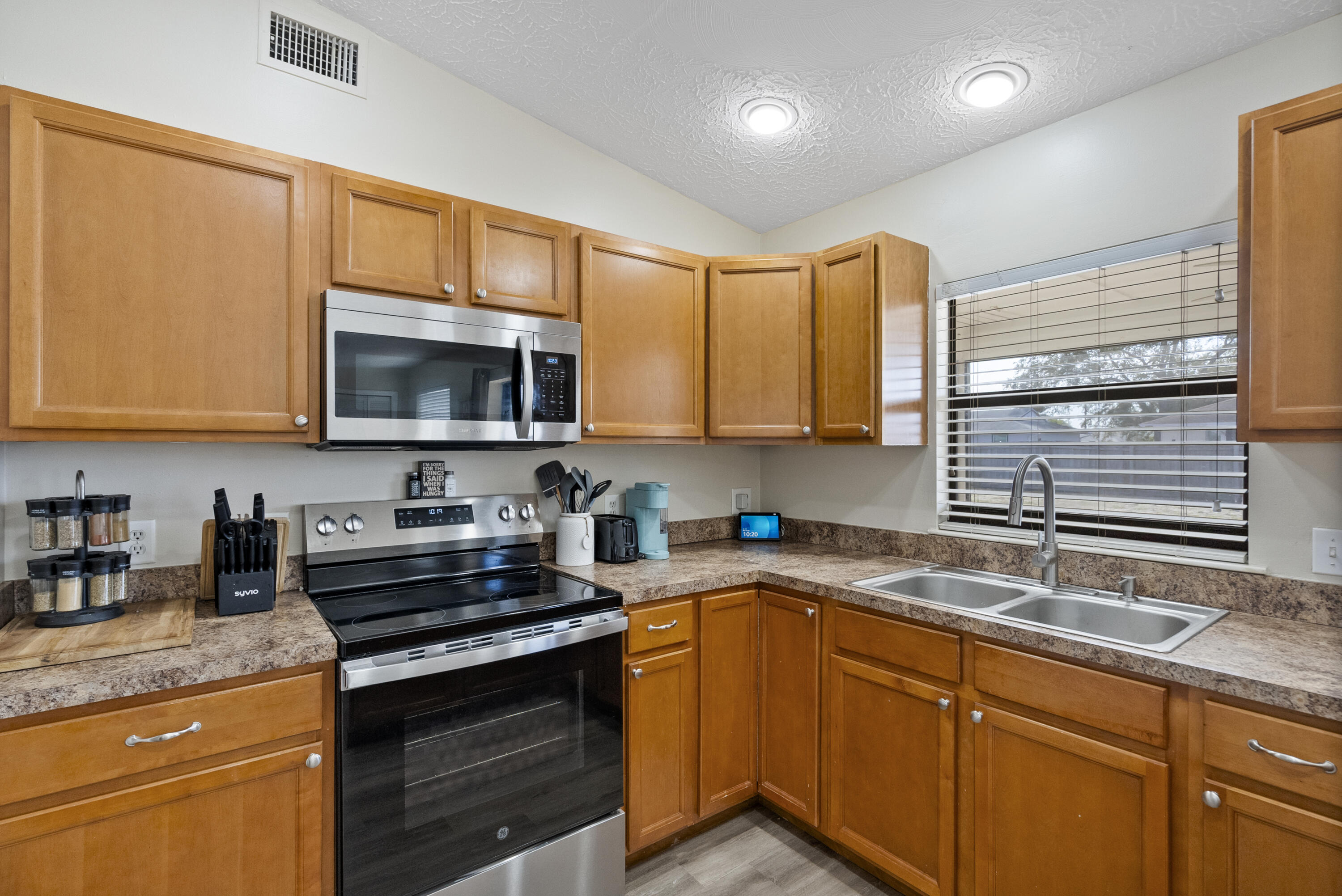 822 Southwest Harvard Road Port St. Lucie, FL 34953 - Photo 13 of 43 a kitchen with sink a microwave and cabinets