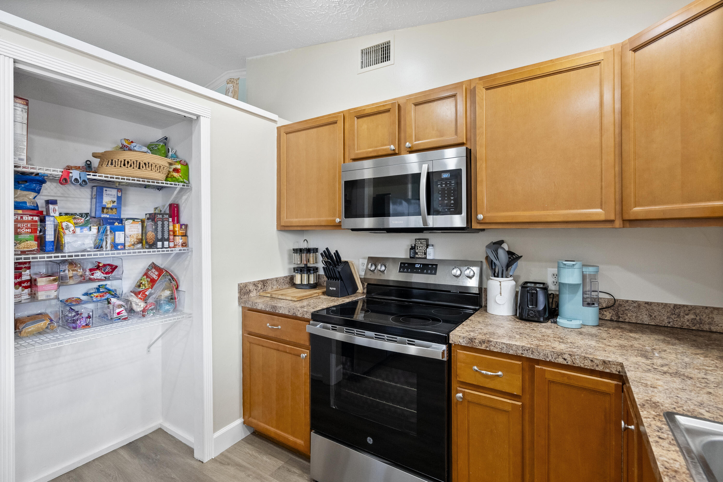 822 Southwest Harvard Road Port St. Lucie, FL 34953 - Photo 14 of 43 a kitchen with stainless steel appliances granite countertop a stove a sink and a microwave