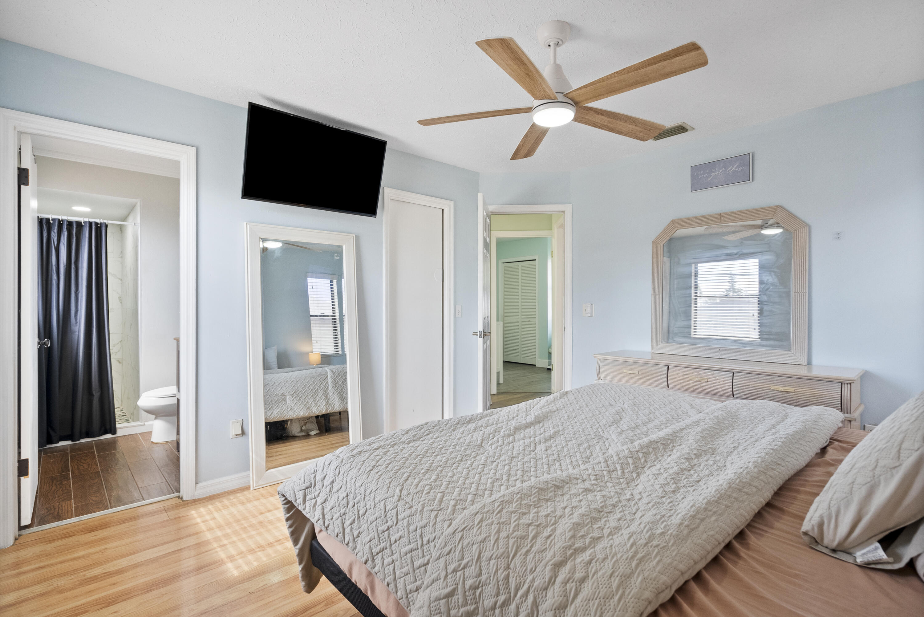 822 Southwest Harvard Road Port St. Lucie, FL 34953 - Photo 20 of 43 a bedroom with a large bed a flat tv screen and a walk in closet