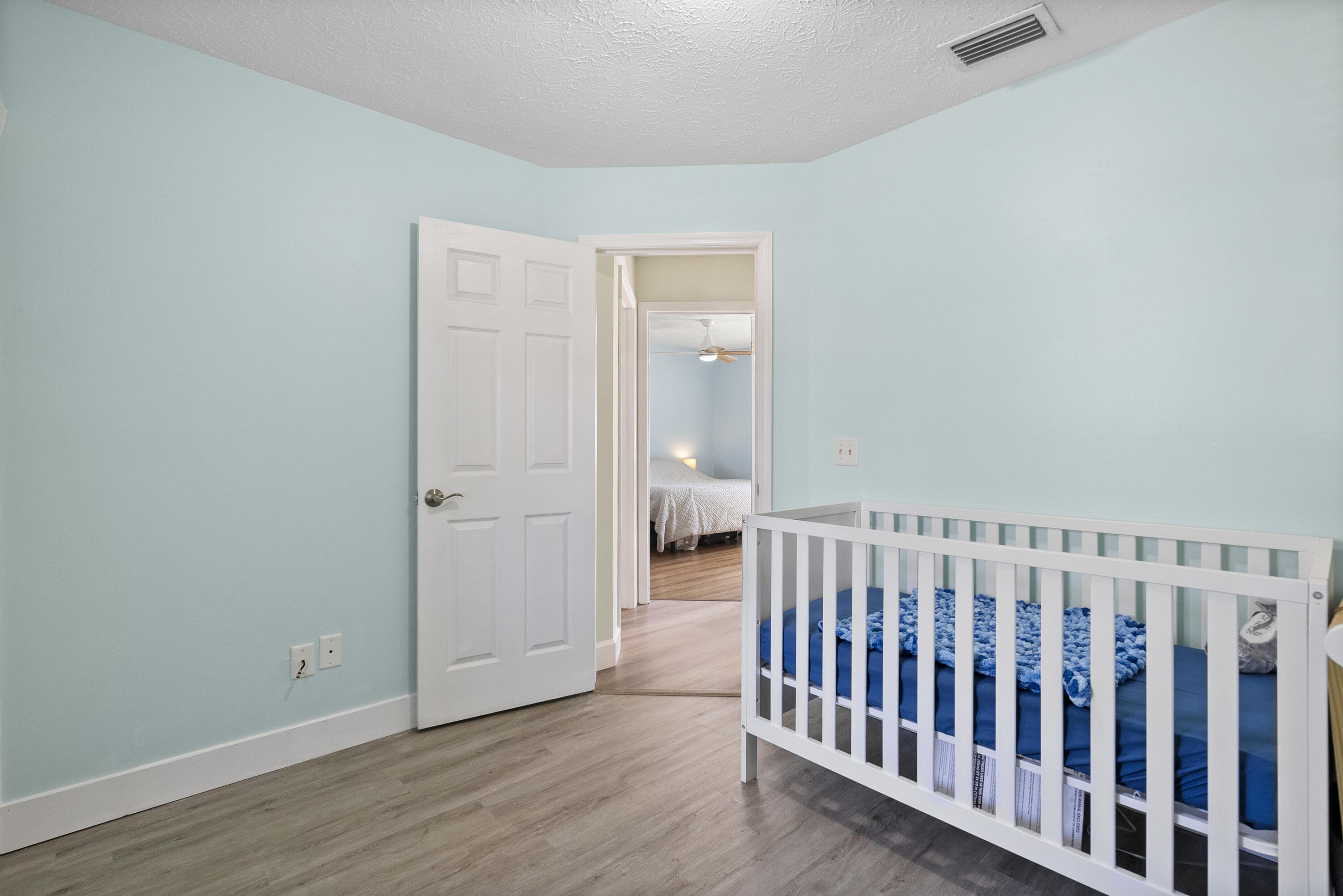 822 Southwest Harvard Road Port St. Lucie, FL 34953 - Photo 26 of 43 a view of a hallway with wooden floor and a bathroom