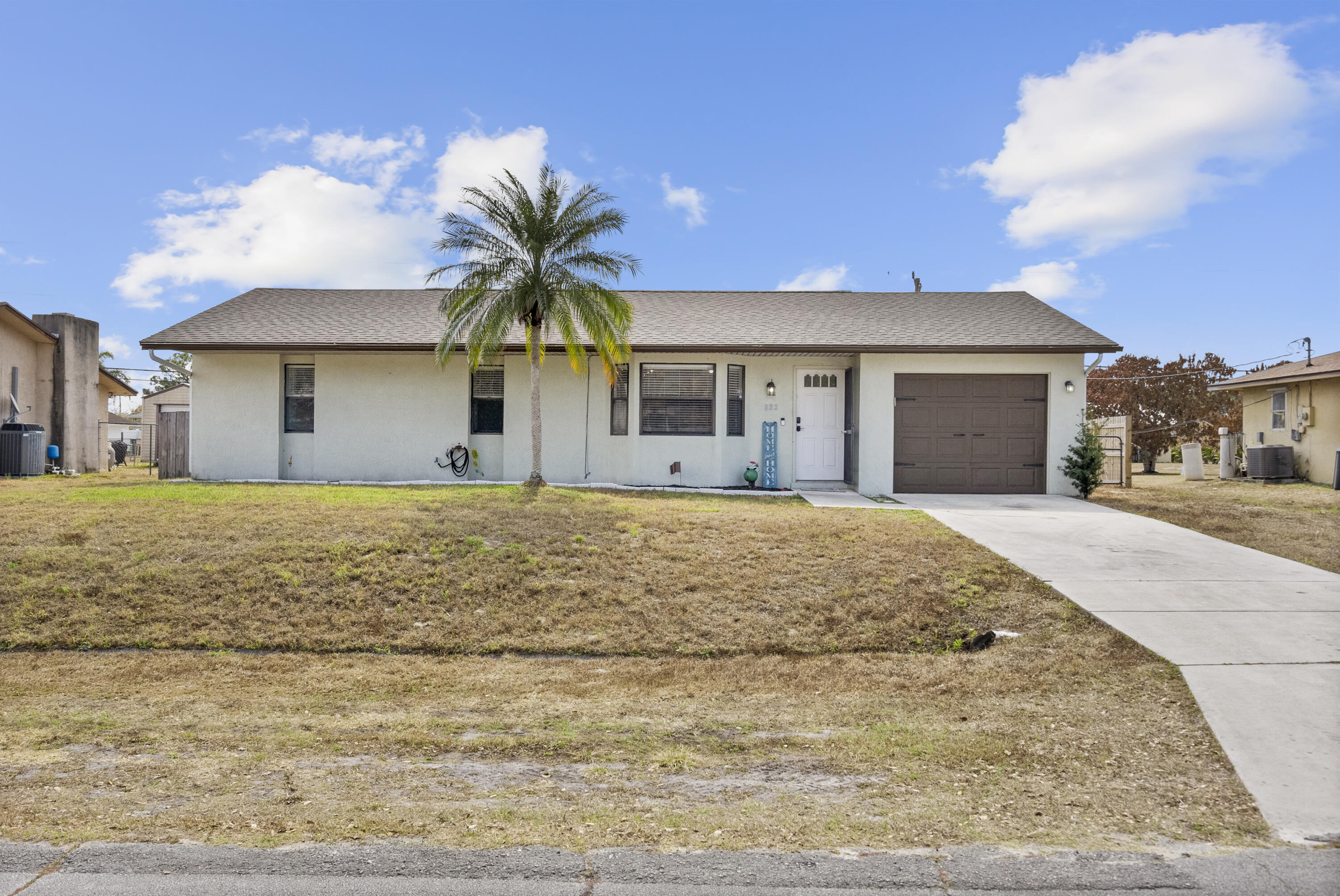 822 Southwest Harvard Road Port St. Lucie, FL 34953 - Photo 3 of 43 a front view of a house with a yard and garage