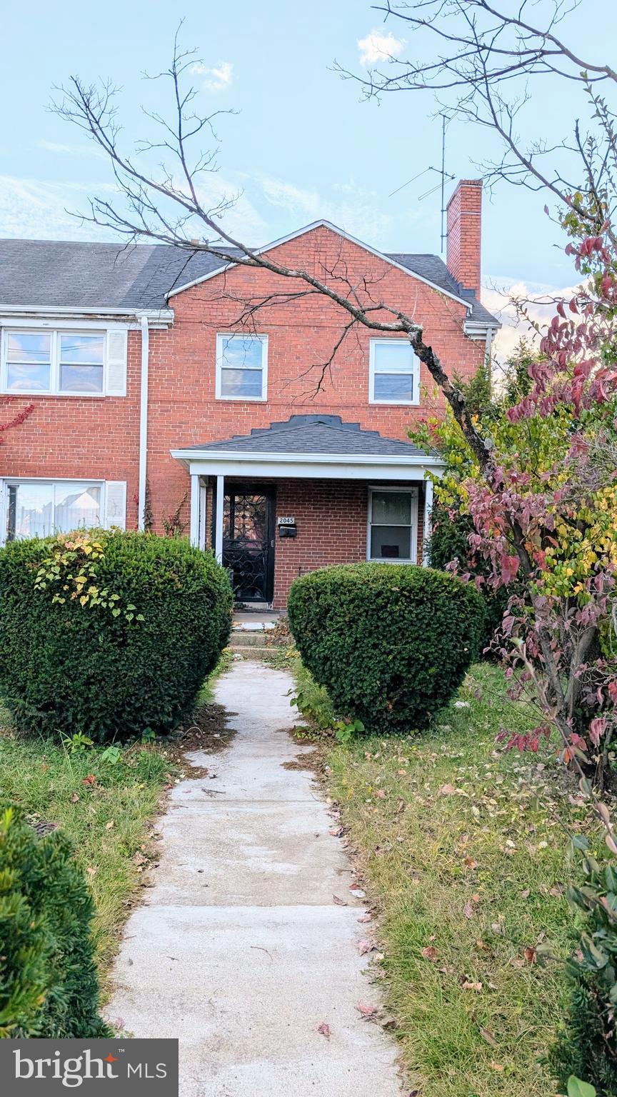 a view of a house with a small yard and potted plants