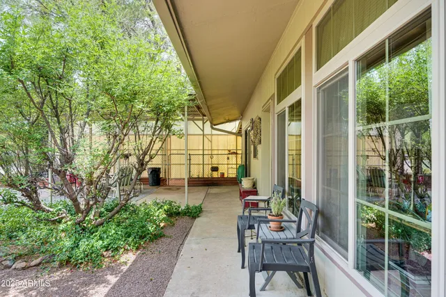 a balcony with chairs and with potted plants