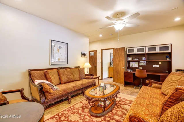 a living room with furniture a rug and a bookshelf