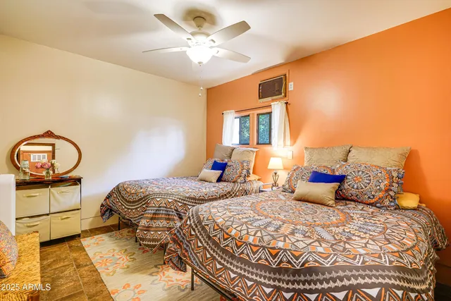 a bedroom with a bed a chandelier and dresser