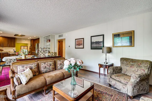 a living room with furniture kitchen view and a window