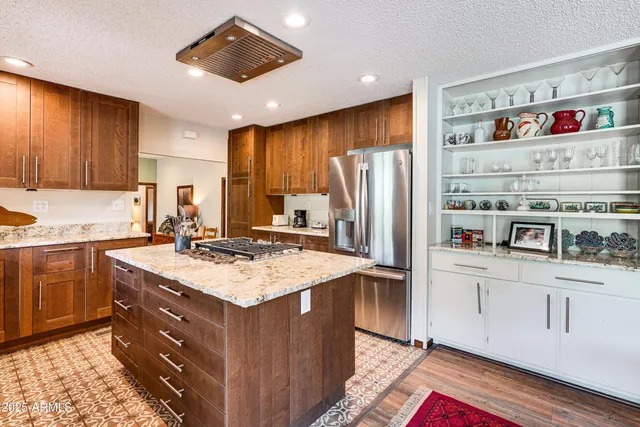 a kitchen with stainless steel appliances granite countertop a refrigerator and a sink
