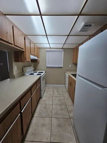 a kitchen with kitchen island granite countertop a stove a sink and a refrigerator