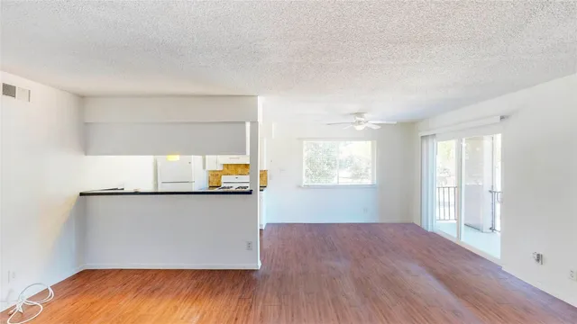an empty room with wooden floor and window