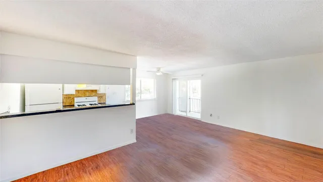 a view of a kitchen with wooden floor and a window