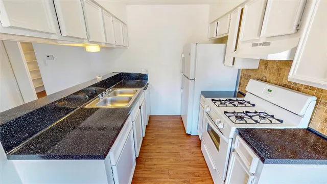 a kitchen with stainless steel appliances granite countertop a stove a sink and a microwave