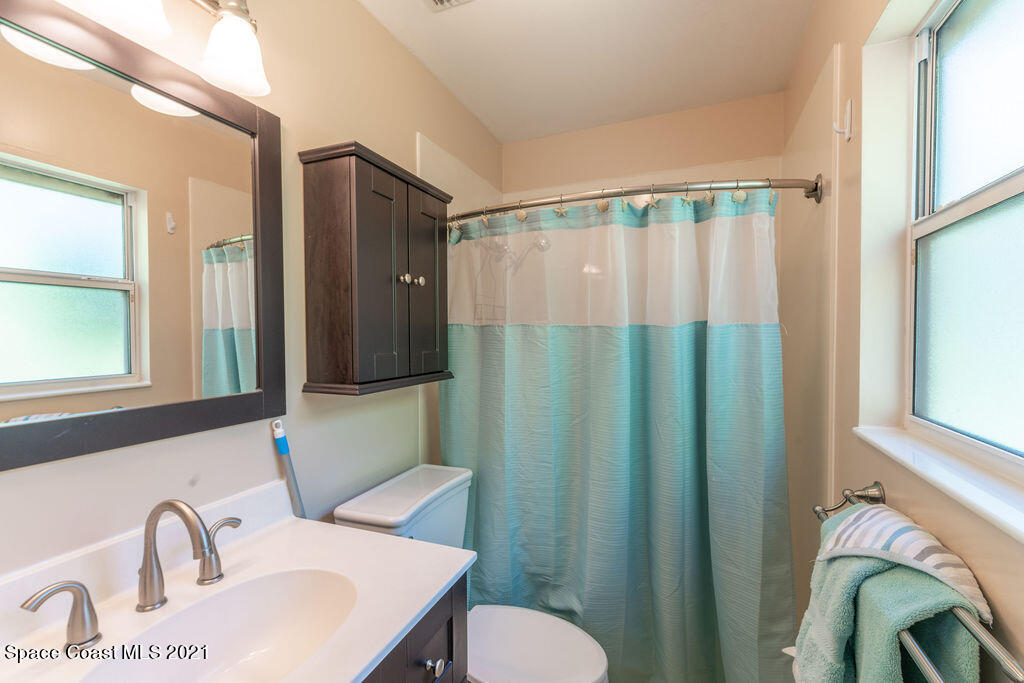 1063 Whitehurst Road Southwest Palm Bay, FL 32908 - Photo 13 of 20 a bathroom with a sink a mirror and a shower