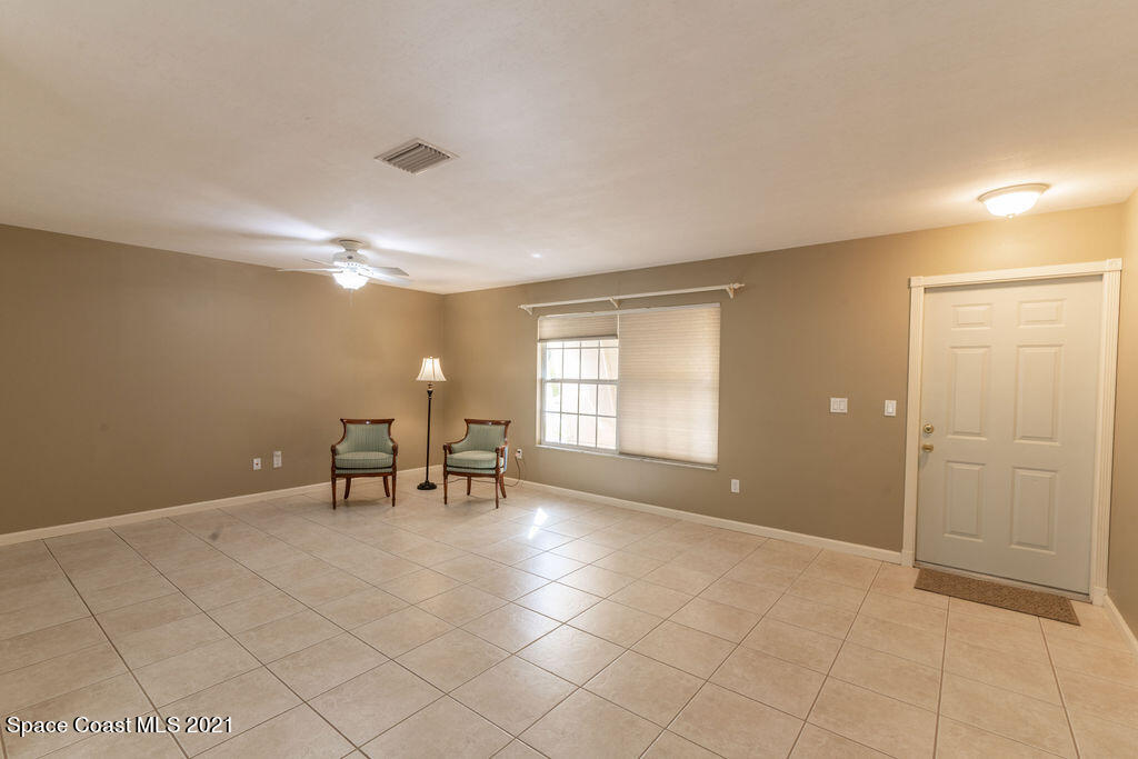 1063 Whitehurst Road Southwest Palm Bay, FL 32908 - Photo 5 of 20 an empty room with windows and table