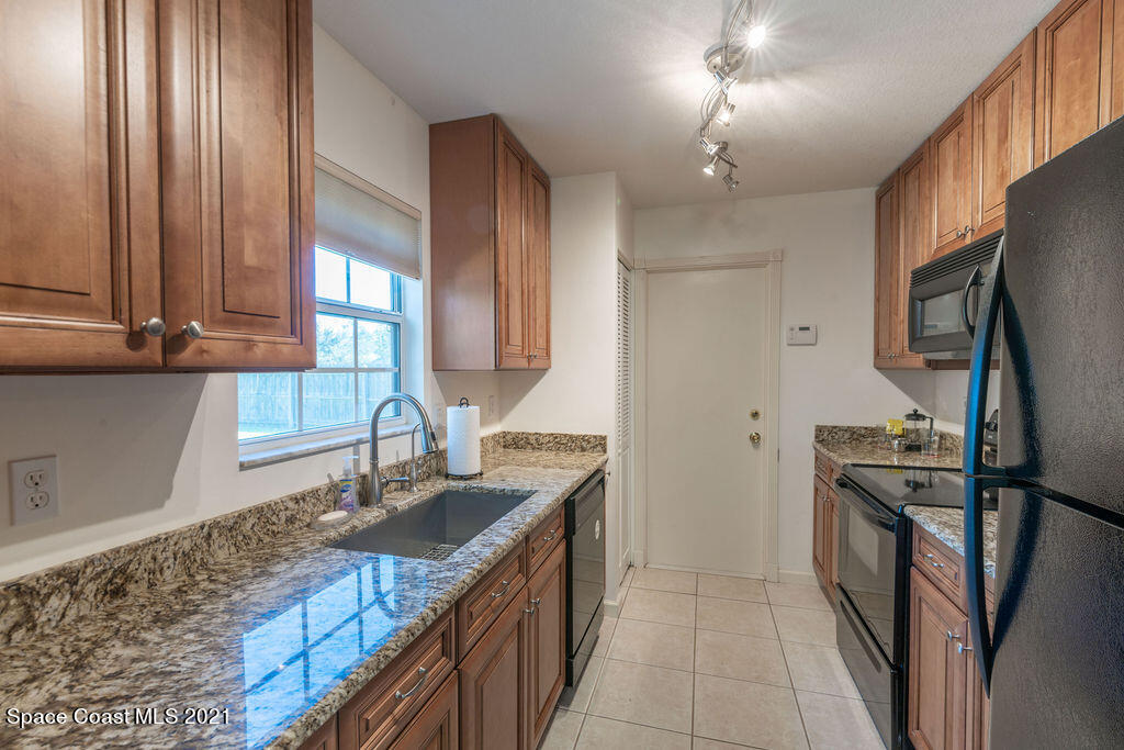 1063 Whitehurst Road Southwest Palm Bay, FL 32908 - Photo 8 of 20 a kitchen with granite countertop a sink stove and refrigerator