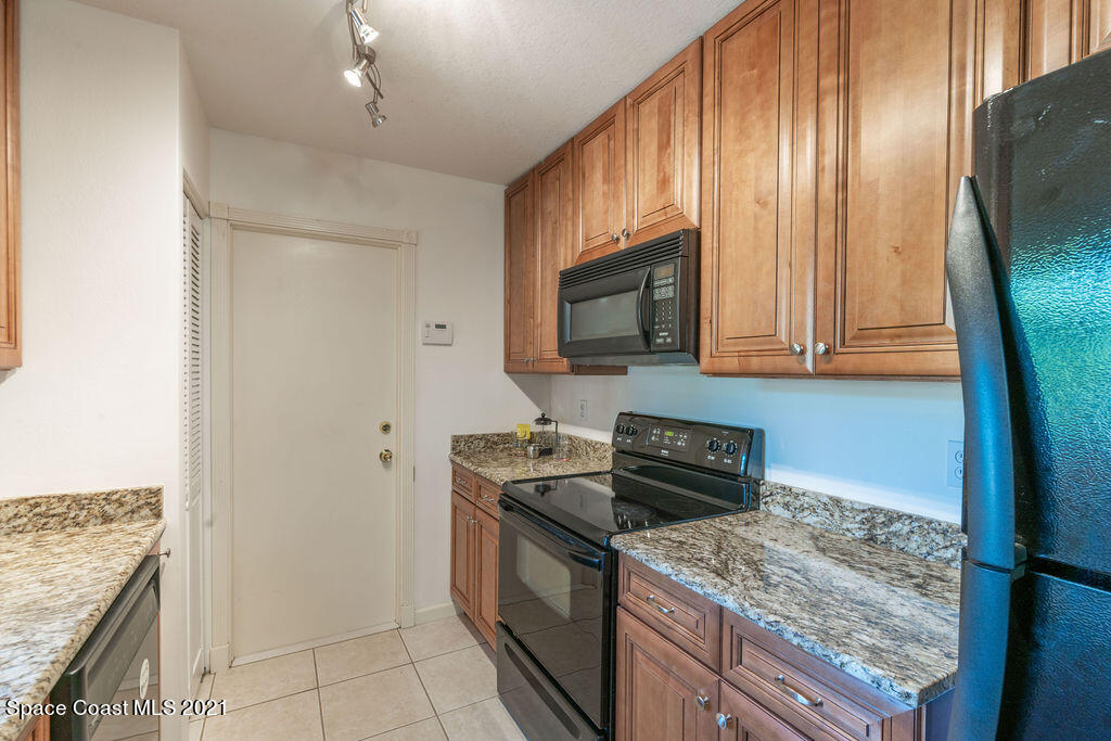 1063 Whitehurst Road Southwest Palm Bay, FL 32908 - Photo 9 of 20 a kitchen with stainless steel appliances granite countertop a stove microwave and sink