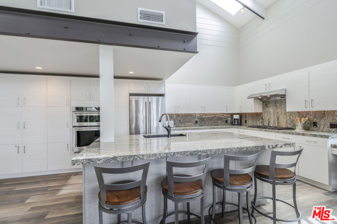191 Rincon Point Road Carpinteria, CA 93013 - Photo 7 of 19 a kitchen with granite countertop a table chairs microwave and cabinets