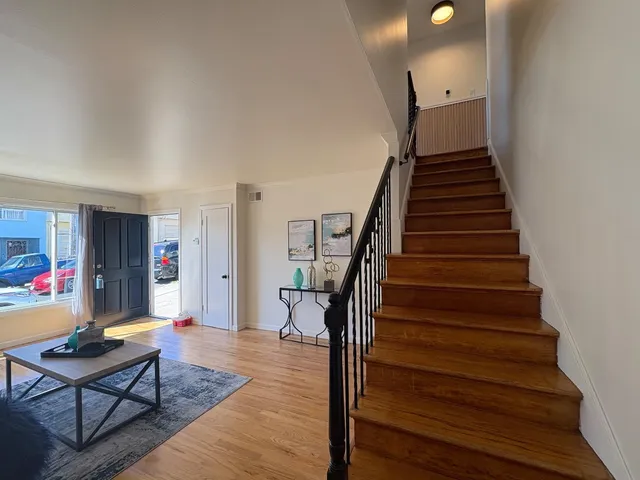 a living room with furniture and a wooden floor