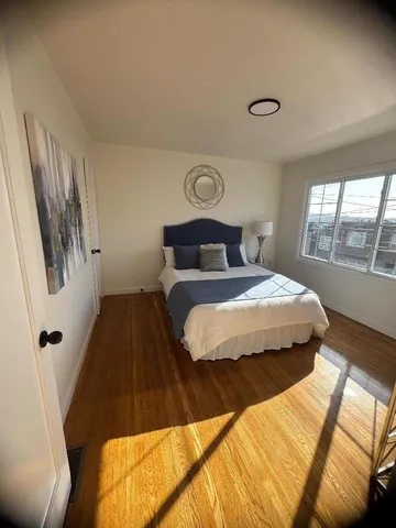 a bedroom with a bed and wooden floor