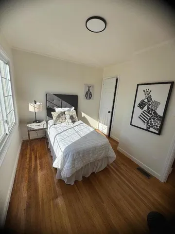 a bedroom with a bed and a large window