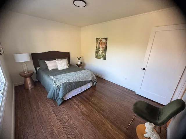 a bedroom with a bed and wooden floor