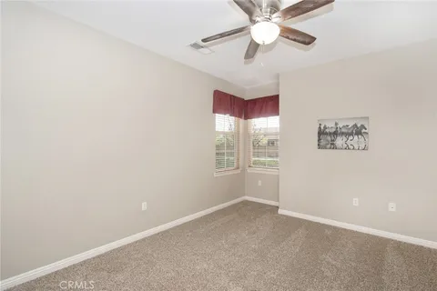 an empty room with a ceiling fan and a window