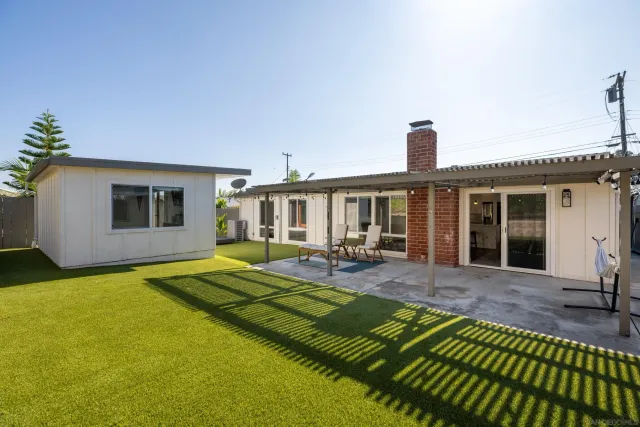 a view of a house with backyard and sitting area