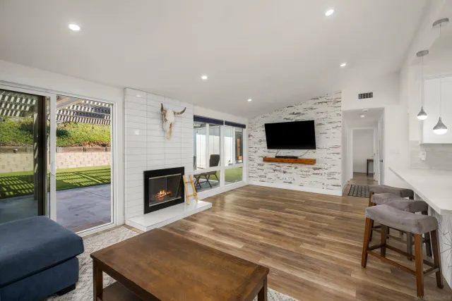 a living room with furniture a flat screen tv and a fireplace