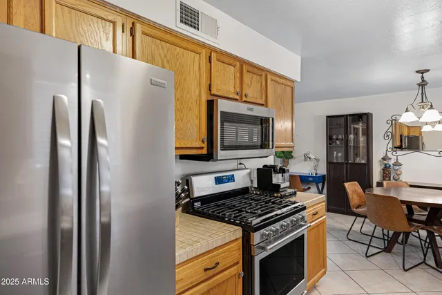 a kitchen with a refrigerator a stove and a dining table