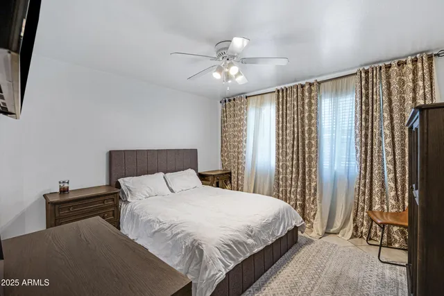 a bedroom with a large bed and a chandelier