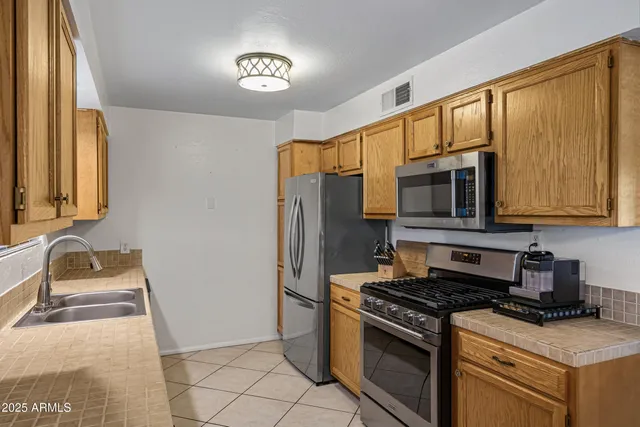 a kitchen with stainless steel appliances granite countertop a stove a sink and a microwave