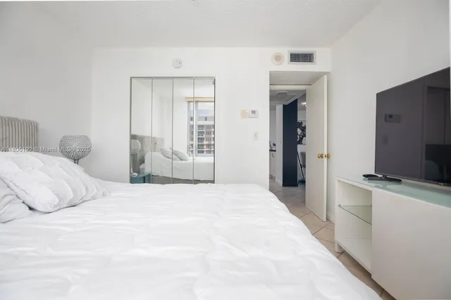 a bedroom with a bed and a flat screen tv