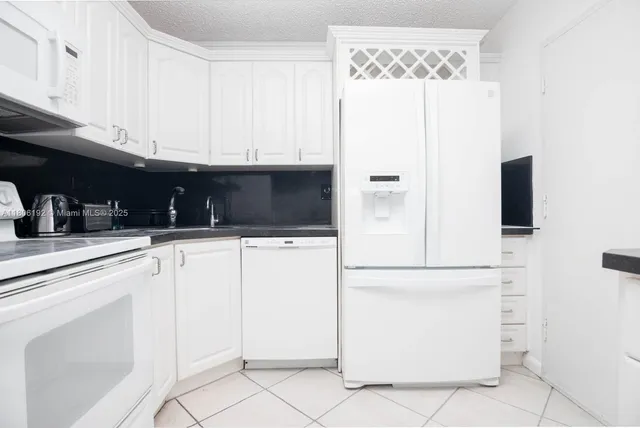 a kitchen with white cabinets and white appliances