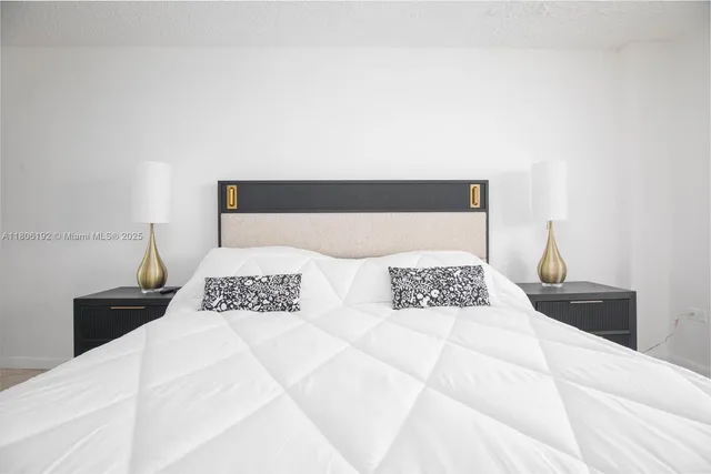 a bedroom with a large bed and a lamp