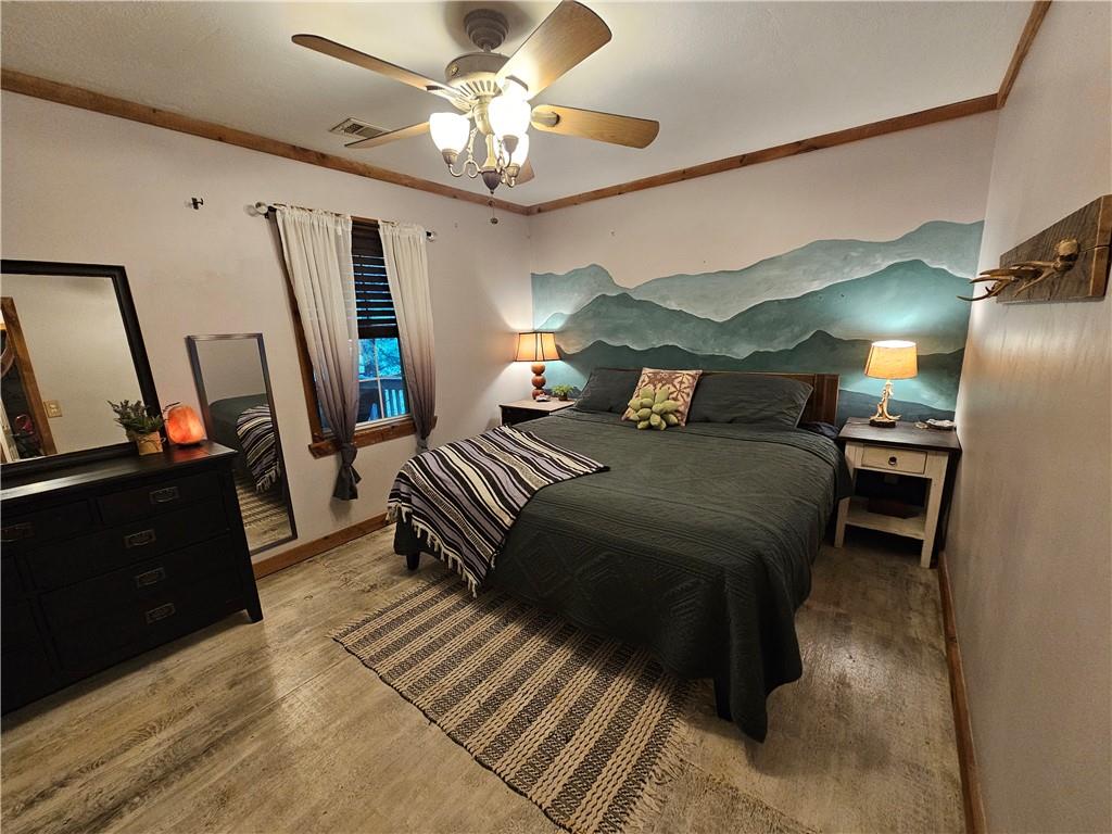 131 Chestatee Spgs Ridge Dahlonega, GA 30533 - Photo 11 of 51 a bedroom with a bed dresser and a flat tv screen