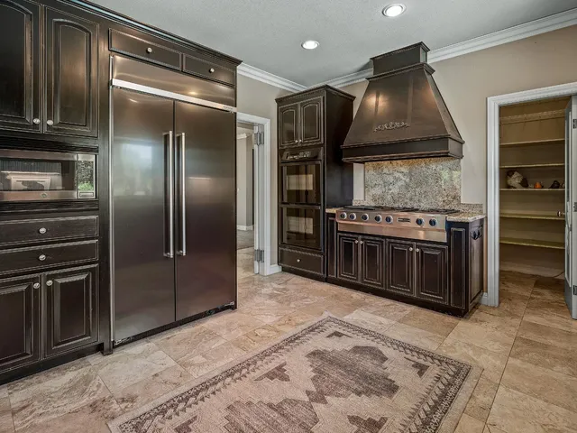 a kitchen with stainless steel appliances granite countertop a stove a refrigerator and a sink