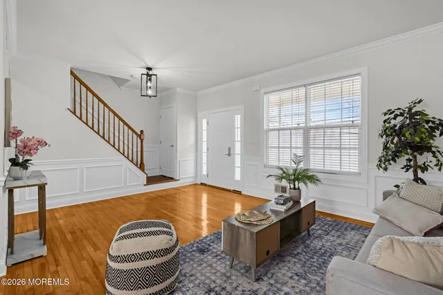 a living room with furniture flowerpot and wooden floor