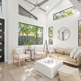 a living room with furniture a fireplace a clock and a large window